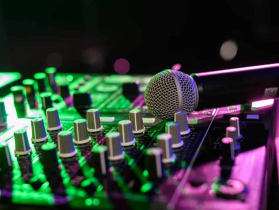 Live analog mixing console in Sydney with a wireless handheld microphone on top of it