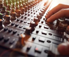 Audio Engineer - Mixing on a mixing desk at a studio